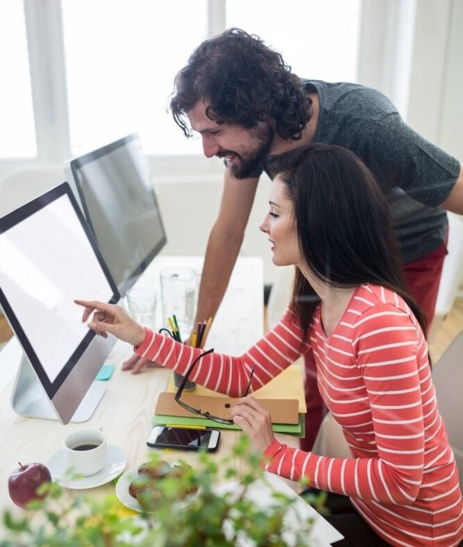 A man and woman at Acceleratron in Pune and Kolkata, engrossed in coding, while looking at a computer screen.